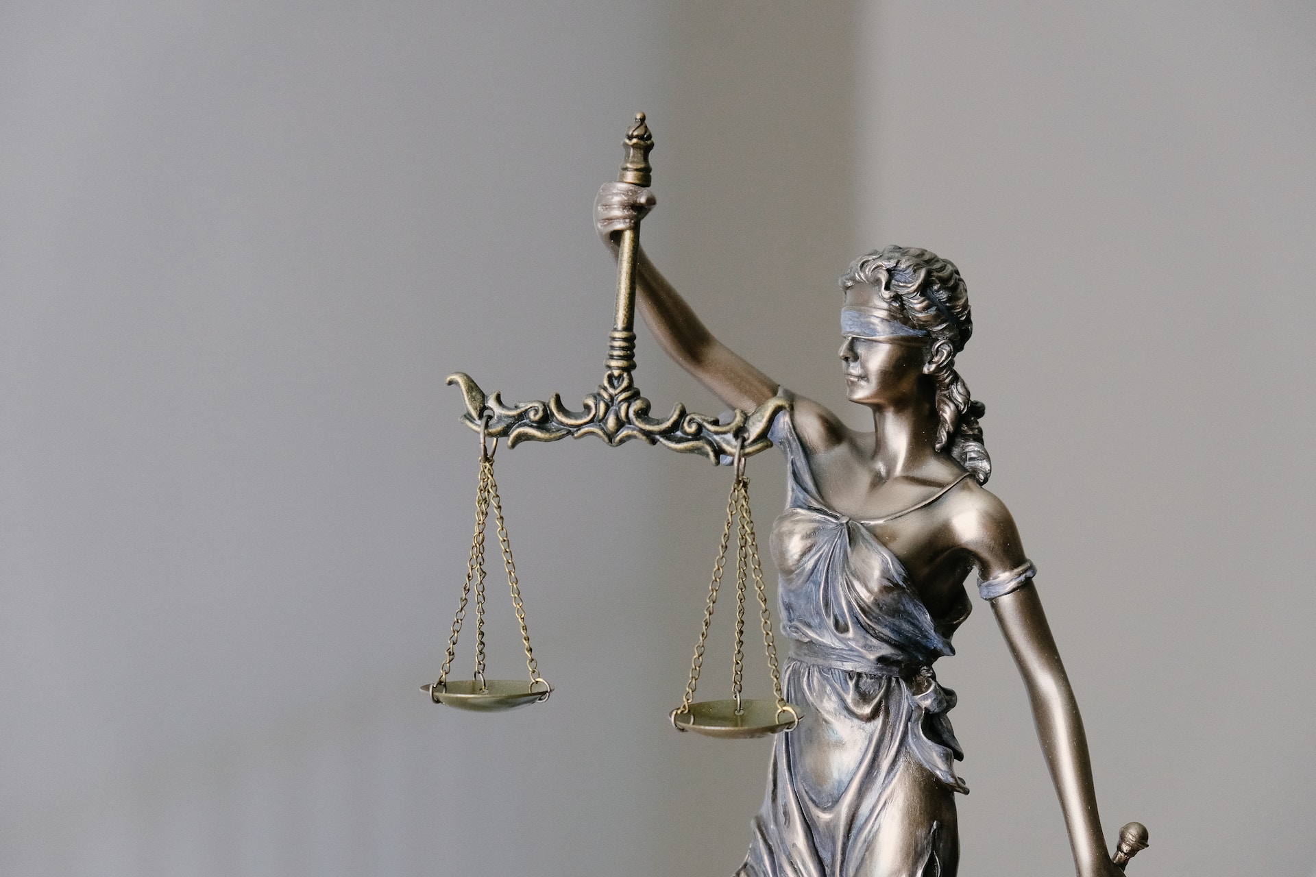 Scales of justice statue against a neutral background